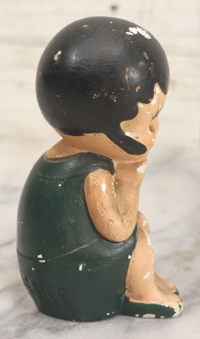 Lot 044 - Vintage Chalkware Kewpie-Style Crouching Flapper Doll With Black Hair And Green Dress, Back Marked "Splash Me", Note Paint Chipping And Wear, 4-3/4" Height