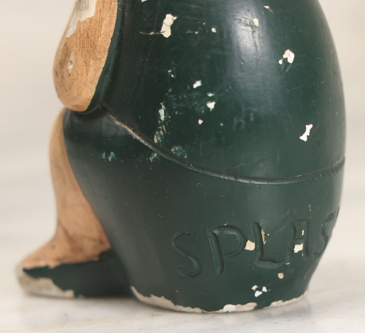 Lot 044 - Vintage Chalkware Kewpie-Style Crouching Flapper Doll With Black Hair And Green Dress, Back Marked "Splash Me", Note Paint Chipping And Wear, 4-3/4" Height