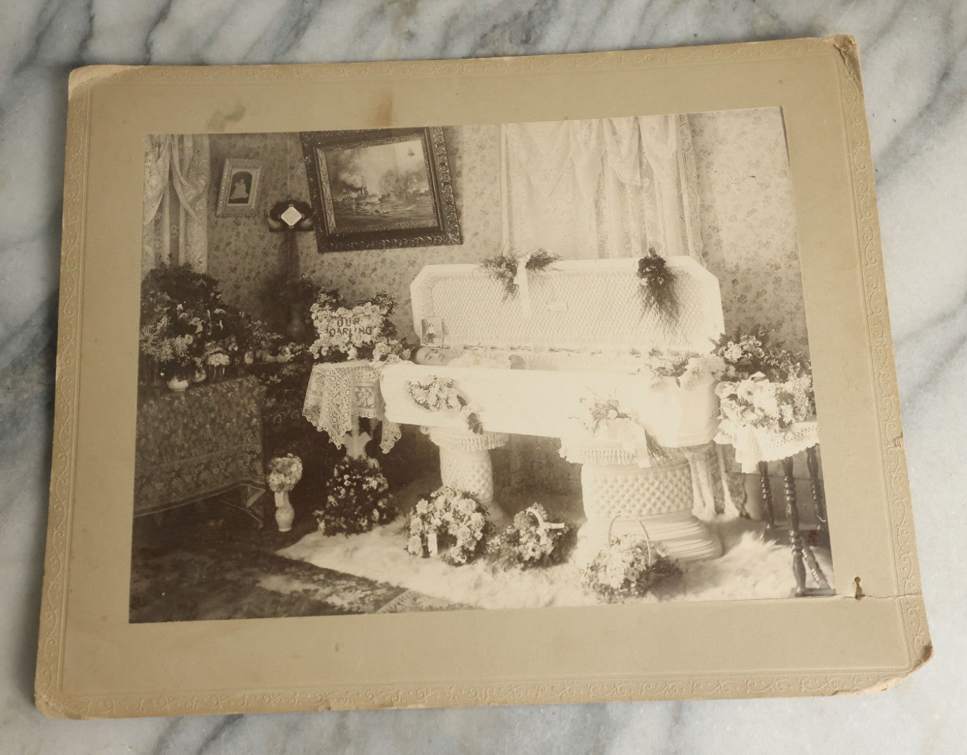 Lot 060 - Antique Boarded Post Mortem Funeral Photograph Of Young Boy In His Casket, With Various Flower Arrangements Including "Our Darling," Paige & Barker, Photographers, Concord, New Hampshire