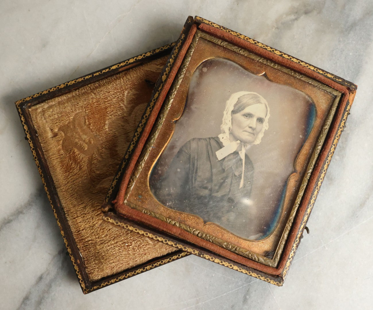 Lot 063 - Antique 1/6th Plate Daguerreotype Photograph With Middle Age Woman With White Hair Wearing White Bonnet And Scarf, In Split Leatherette Union Case With Bird Design