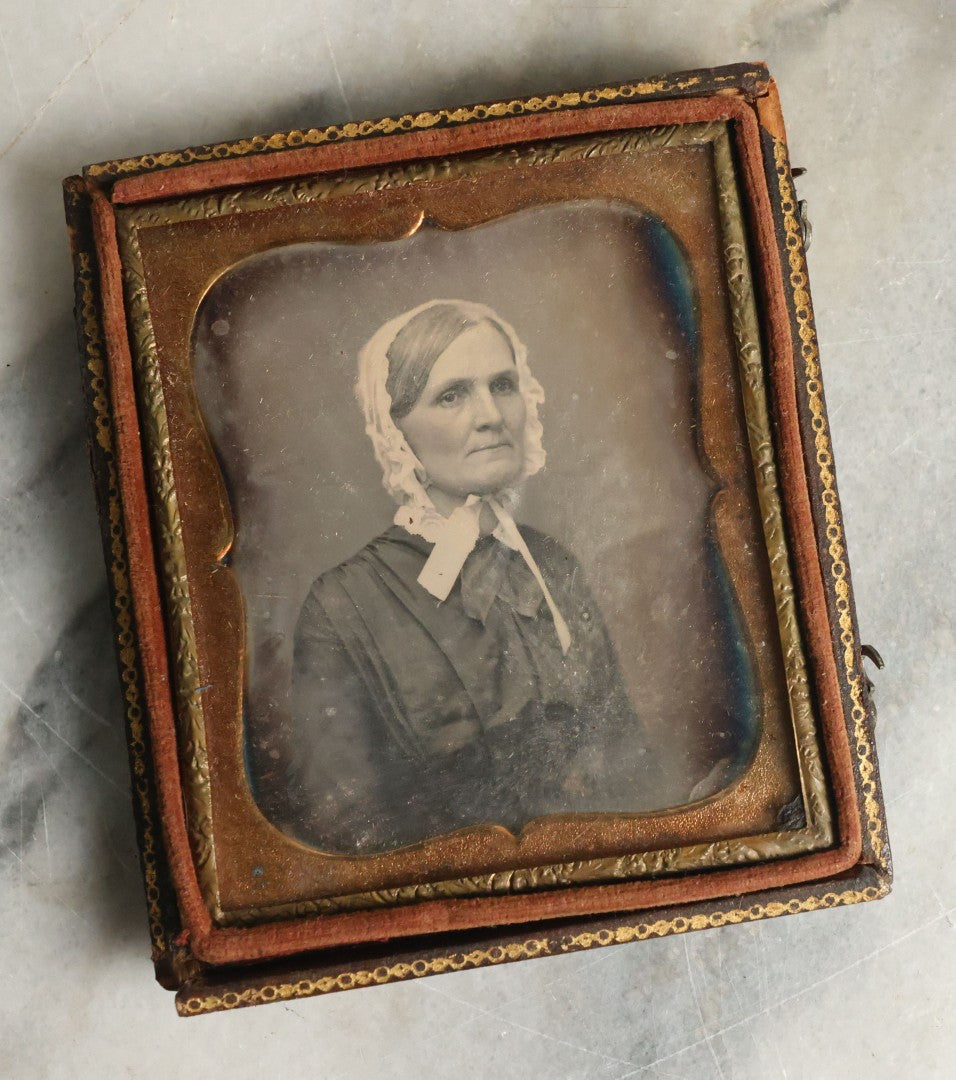 Lot 063 - Antique 1/6th Plate Daguerreotype Photograph With Middle Age Woman With White Hair Wearing White Bonnet And Scarf, In Split Leatherette Union Case With Bird Design