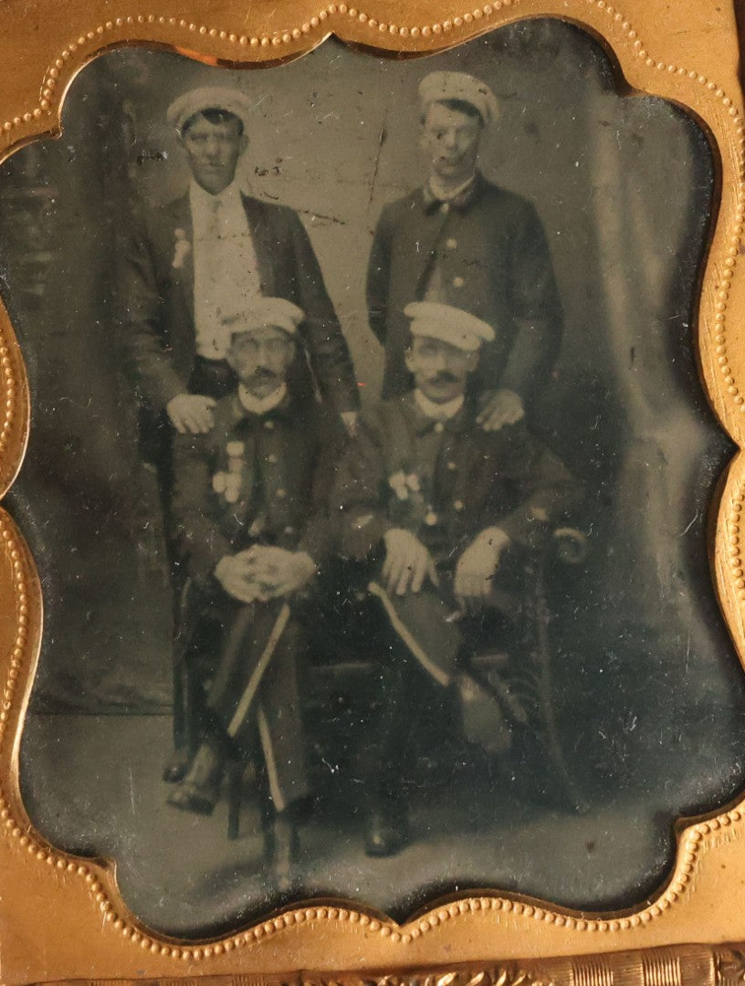 Lot 070 - Antique 1/6th Plate Tintype Photograph With Brass Mat And Preserver Of Four Well Dressed Fraternal Men Wearing Hats And Badges