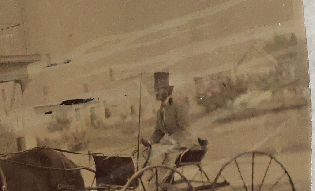 Lot 074 - Antique Outdoor Tintype Photograph Of Man In Stovepipe Hat Sitting On Horse Drawn Cart In Front Of A Building With Partial Sign Visible And Houses In Background