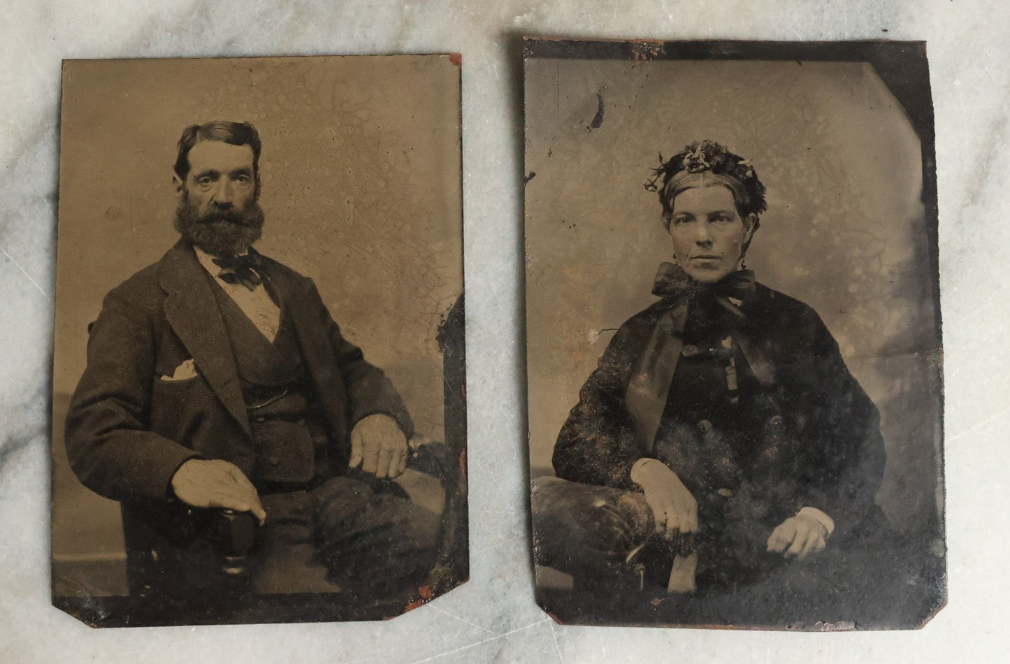Lot 075 - Pair Of Tintype Photographs Of An Old Man With Large Hands And Unusual Face And Big Bushy Beard, And Stern Woman With Large Neck Bow