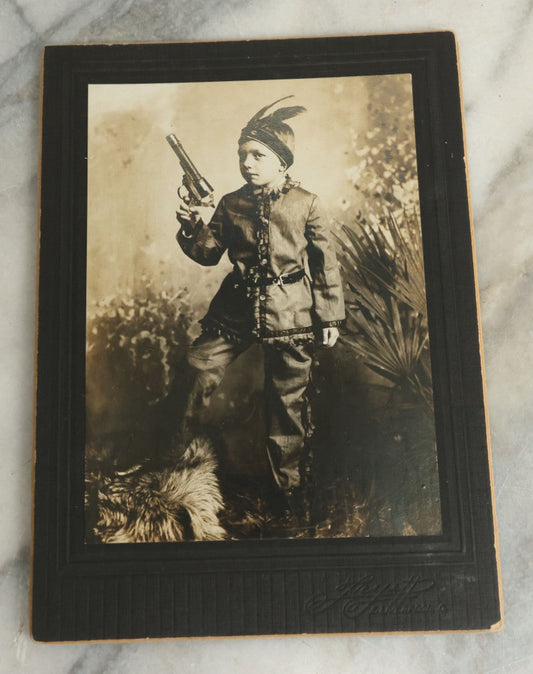 Lot 083 - Antique Boarded Photograph Of Young Boy Dressed As Native American Holding Revolver Pistol, Dated March 4, 1909
