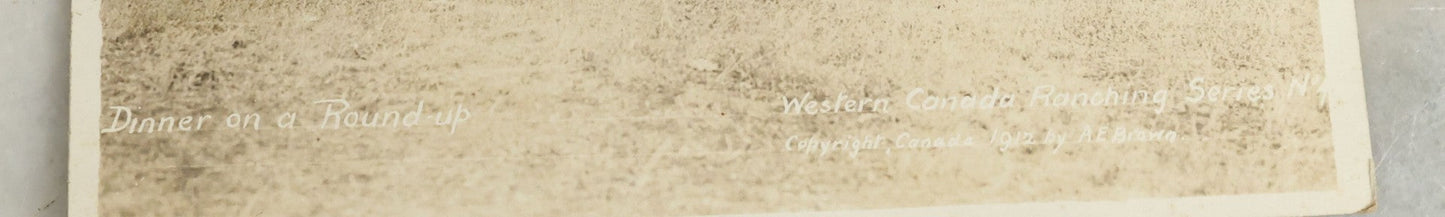 Lot 092 - Antique Real Photo Postcard R.P.P.C. Of Group Of Cowboys, Captioned "Dinner On A Roundup, Western Canada Ranching Series," Copyright 1912, By A.E. Brown