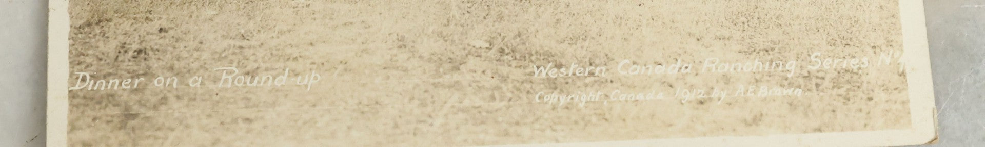 Lot 092 - Antique Real Photo Postcard R.P.P.C. Of Group Of Cowboys, Captioned "Dinner On A Roundup, Western Canada Ranching Series," Copyright 1912, By A.E. Brown