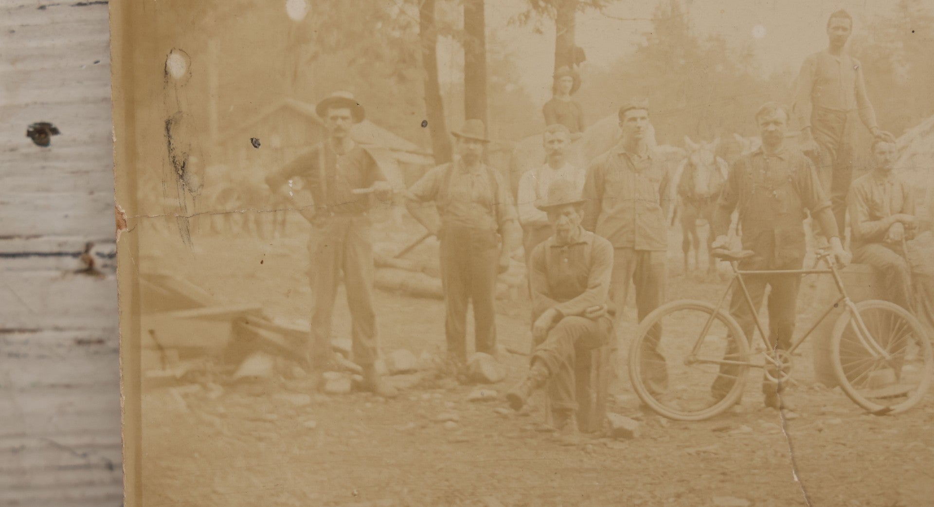 Lot 068 - Antique Boarded Occupational Photograph Of Group Of Lumber Workers Posing At A Lumber Camp In Mifflin County, Pennsylvania, Partial Identification On Verso Of "Grandpa Hoff", Bicycle And Horse In Photo, Note Cracking And Wear