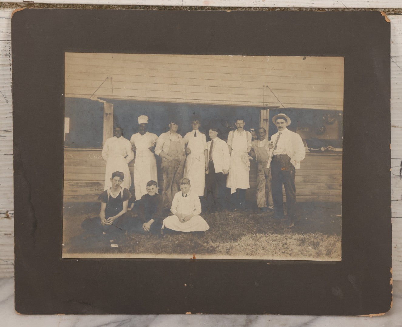 Lot 075 - Antique Boarded Occupational Photograph Of Cooks And Workers Outside Chow Hall, With Chow Hall In Background Featuring Several Moxie Soda Advertisements