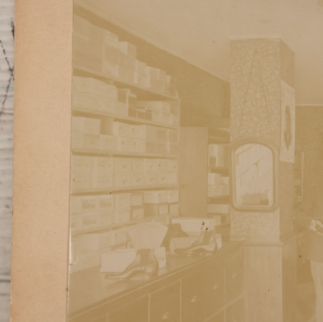 Lot 076 - Antique Boarded Photograph Of Three Men And Young Boy In Boot And Shoe Store, With Products And Advertising Visible In Photo