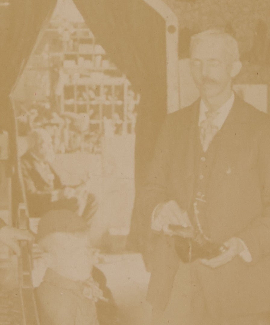 Lot 076 - Antique Boarded Photograph Of Three Men And Young Boy In Boot And Shoe Store, With Products And Advertising Visible In Photo