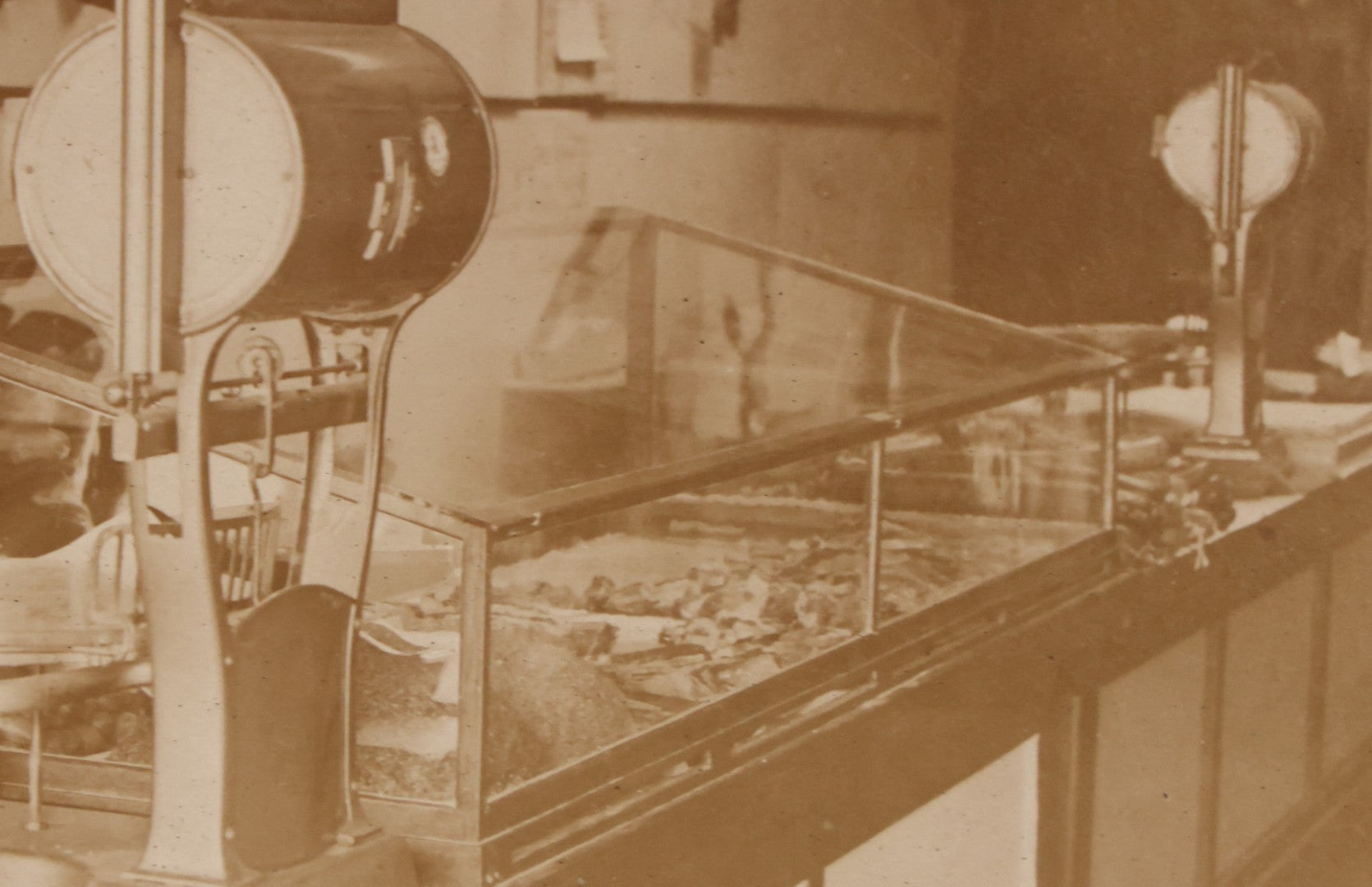 Lot 077 - Antique Boarded Occupational Photograph Of Two Butchers Behind Counter, With Sausage, Full Pig, And Other Meat Products Visible In Photo, And Large Commercial Scale