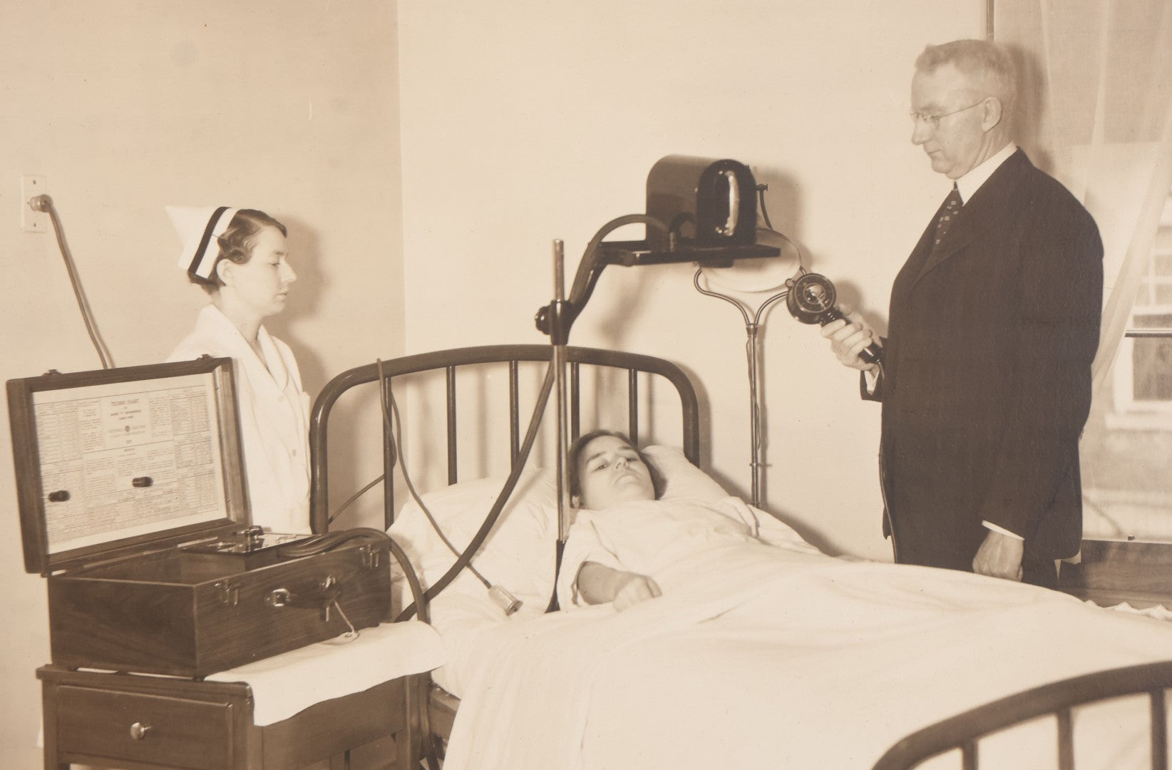 Lot 080 - Vintage Photograph In Paper Frame Of Woman In Hospital Bed With Her Nurse And Doctor About To Utilize An Unknown Medical Apperatus, C.L. Smith & Co., Photographers, Norwood, Massachusetts