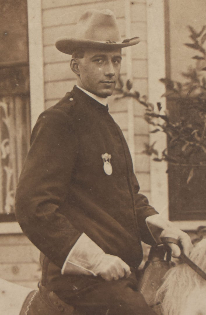 Lot 083 - Antique Boarded Photograph Of Man In Uniform Sitting Horseback On White Horse With Saddle Blanket Emblazoned With Star, Western Hat And Badge