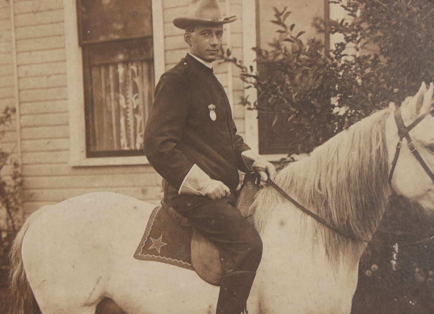 Lot 083 - Antique Boarded Photograph Of Man In Uniform Sitting Horseback On White Horse With Saddle Blanket Emblazoned With Star, Western Hat And Badge