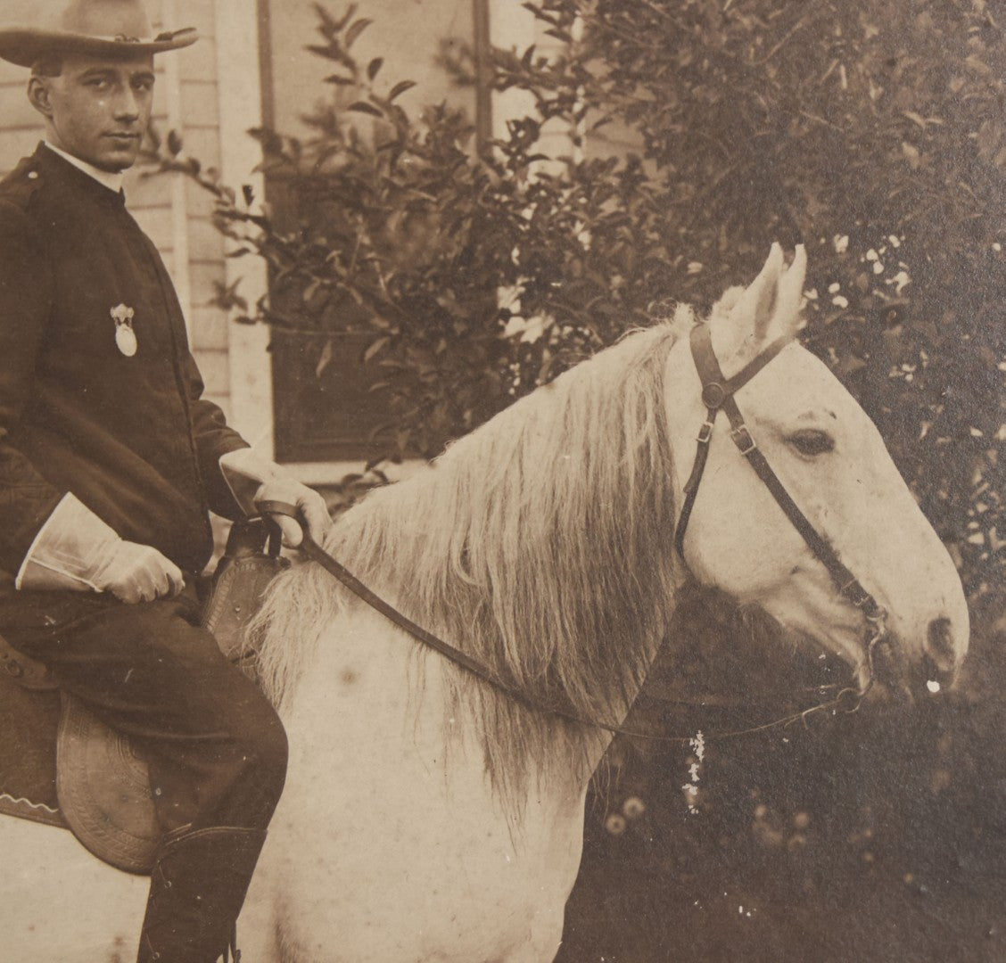 Lot 083 - Antique Boarded Photograph Of Man In Uniform Sitting Horseback On White Horse With Saddle Blanket Emblazoned With Star, Western Hat And Badge