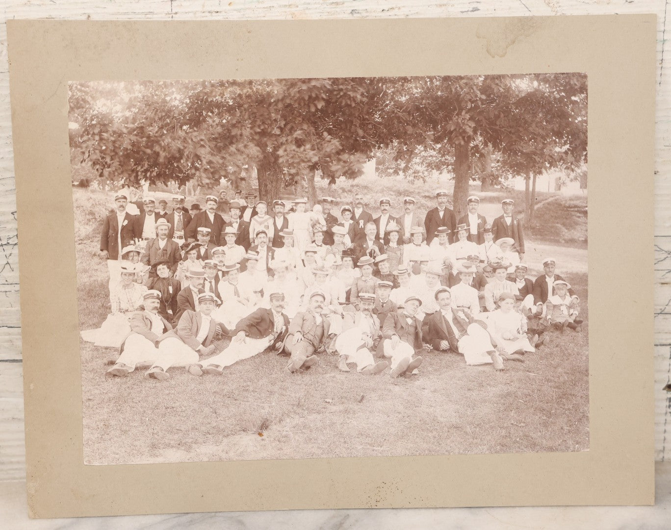 Lot 107 - Antique Double Sided Boarded Photograph Of Outing Of Fancy Dressed Men In White Pants, White Caps, With Ribbons And Their Wives