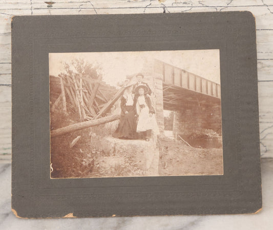 Lot 109 - Antique Boarded Photograph Of Two Women And Man Posing Beside Partially Collapsed Railroad Bridge