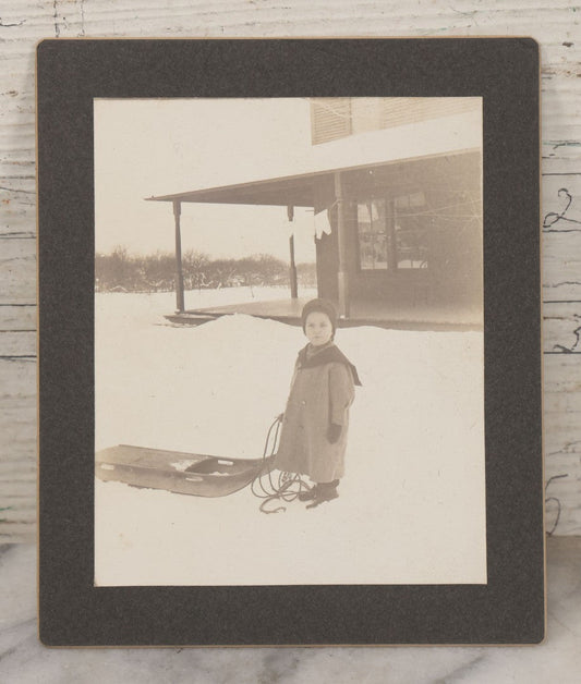 Lot 120 - Antique Boarded Photograph Of Young Boy Posing In Snow With Wooden Sled In Front Of Farmer's Porch