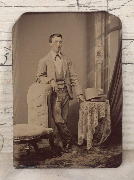 Lot 131 - Single Antique Tintype Photograph Of Confident Man Leaning On Chair Beside Table With Tophat And Book