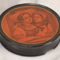 Lot 011 - Antique Laquered Papier Mache Dresser Box With Lithographed Lid Of One Woman Comforting Another, Note Small Loss To Bottom Lip