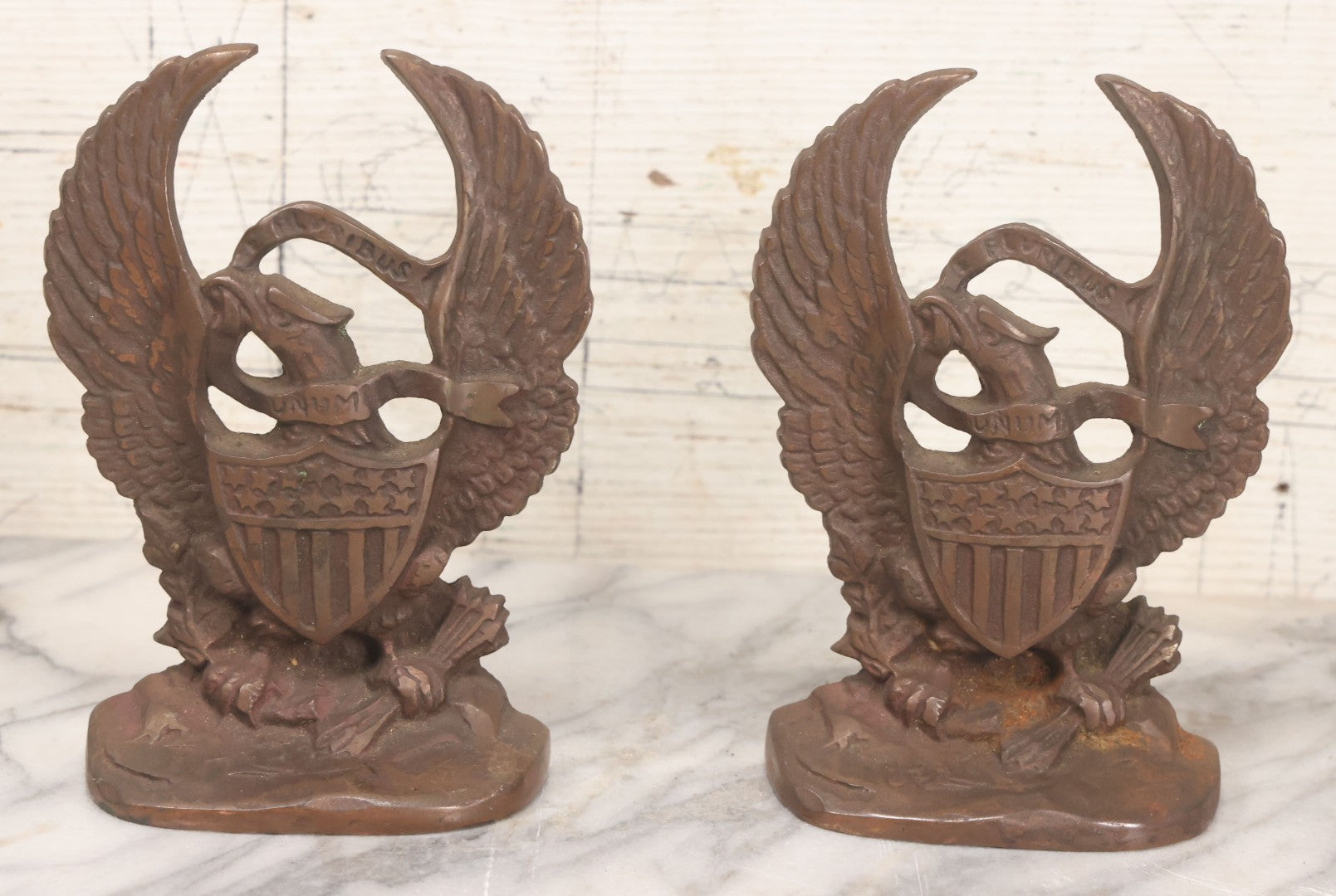 Lot 023 - Pair Of Vintage Bronzed Cast Iron Bookends With Patriotic Eagle Clutching Olive Branch And Arrows, With Shield And "E. Pluribus Unum" Banner