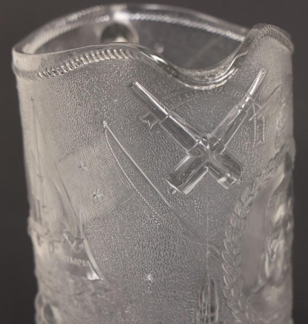 Lot 027 - Antique Early American Pattern Glass E.A.P.G. Spanish American War Battle Of Manila Bay Commemorative Pitcher With Admiral Dewey And U.S.S. Olympia, Patriotic Symbols Including Weaponry And Flags, Manufactured By Beatty-Brady Glass Co., Indiana