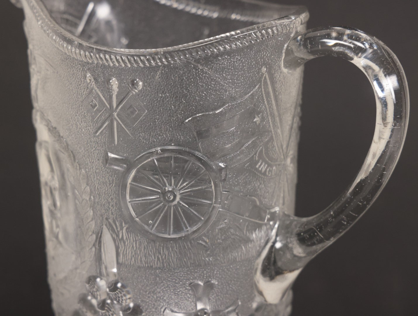Lot 027 - Antique Early American Pattern Glass E.A.P.G. Spanish American War Battle Of Manila Bay Commemorative Pitcher With Admiral Dewey And U.S.S. Olympia, Patriotic Symbols Including Weaponry And Flags, Manufactured By Beatty-Brady Glass Co., Indiana
