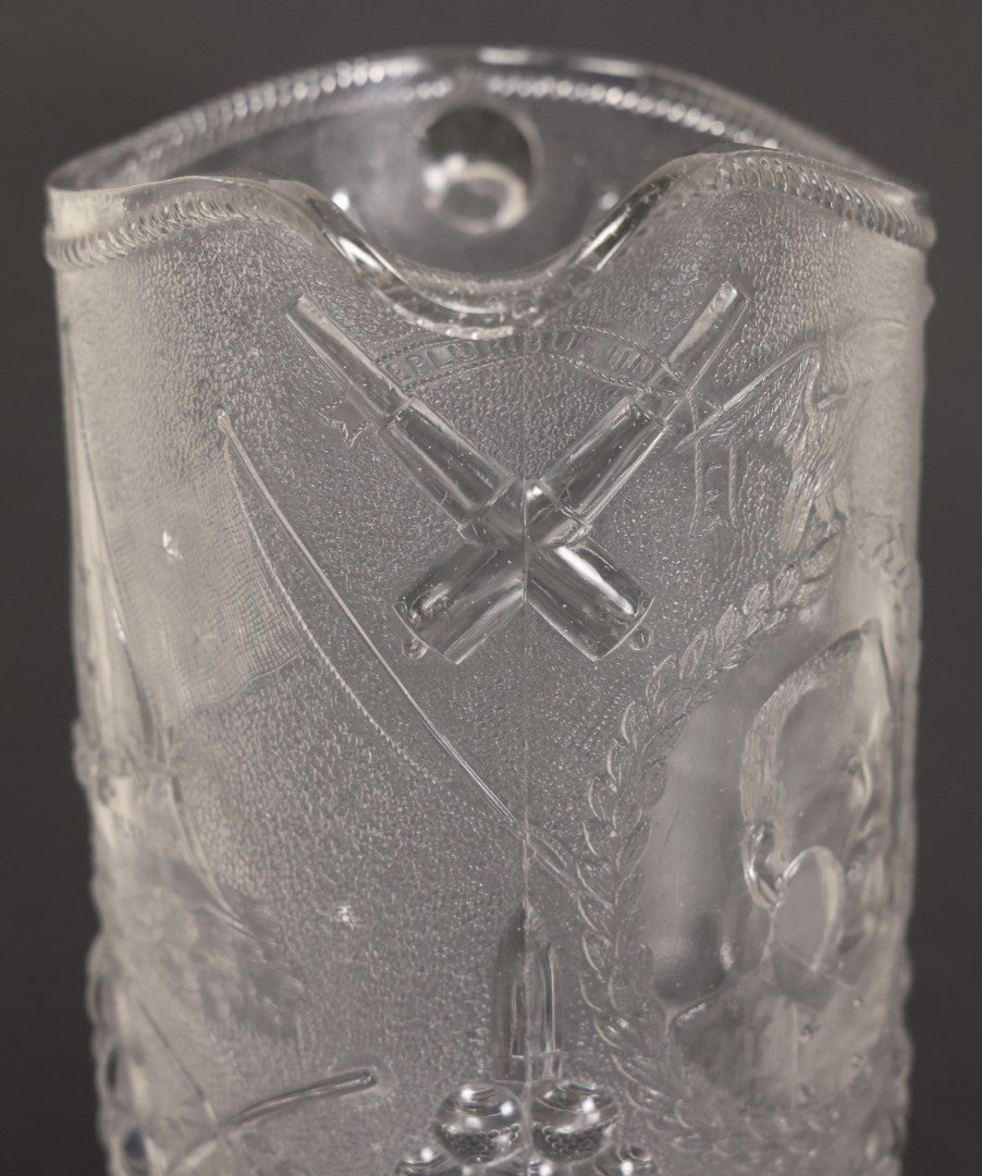 Lot 027 - Antique Early American Pattern Glass E.A.P.G. Spanish American War Battle Of Manila Bay Commemorative Pitcher With Admiral Dewey And U.S.S. Olympia, Patriotic Symbols Including Weaponry And Flags, Manufactured By Beatty-Brady Glass Co., Indiana