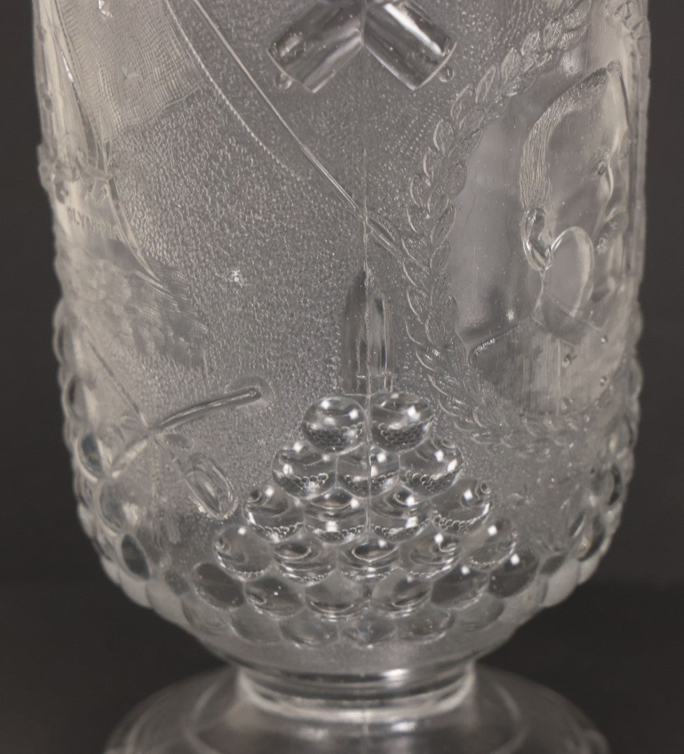 Lot 027 - Antique Early American Pattern Glass E.A.P.G. Spanish American War Battle Of Manila Bay Commemorative Pitcher With Admiral Dewey And U.S.S. Olympia, Patriotic Symbols Including Weaponry And Flags, Manufactured By Beatty-Brady Glass Co., Indiana