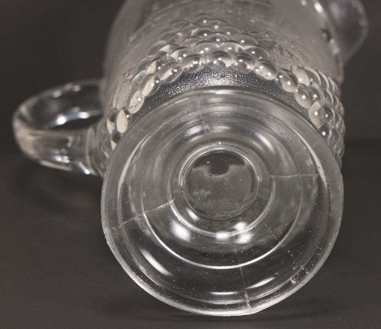 Lot 027 - Antique Early American Pattern Glass E.A.P.G. Spanish American War Battle Of Manila Bay Commemorative Pitcher With Admiral Dewey And U.S.S. Olympia, Patriotic Symbols Including Weaponry And Flags, Manufactured By Beatty-Brady Glass Co., Indiana