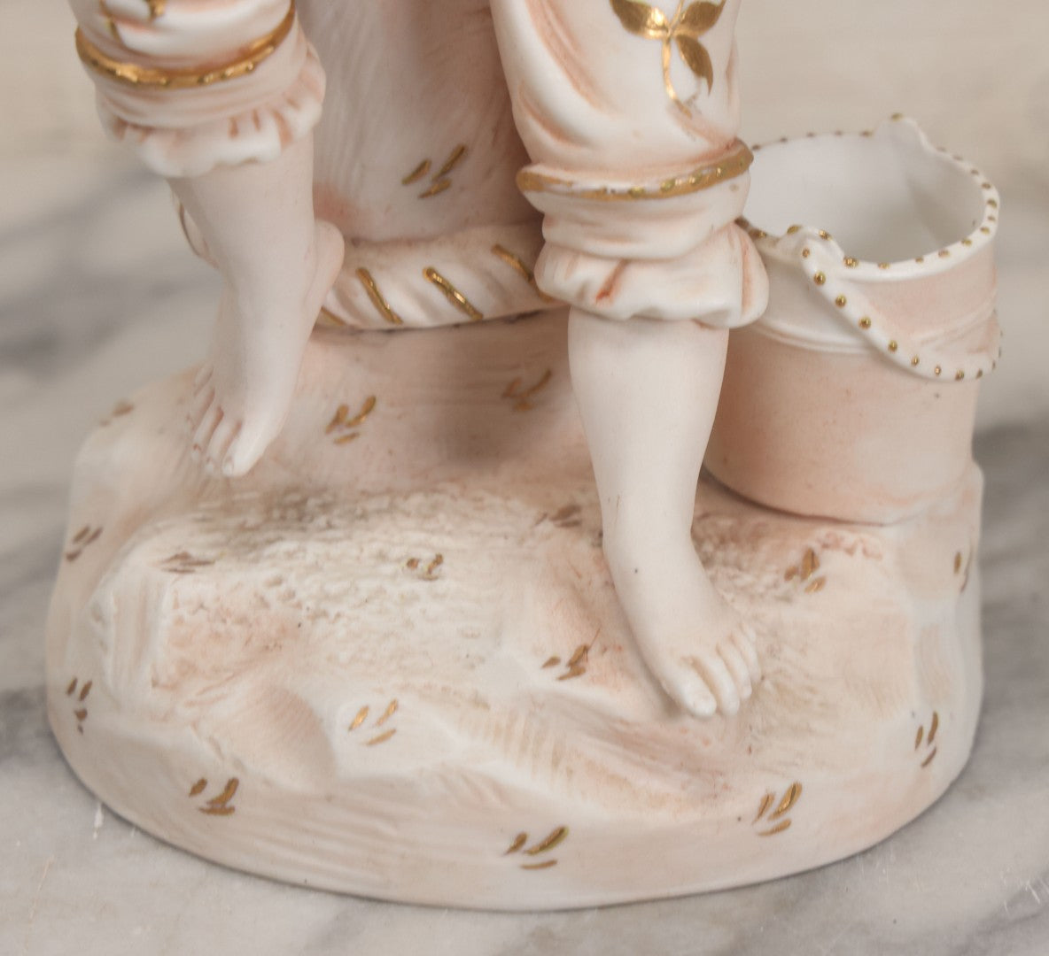 Lot 037 - Vintage Bisque Statue Of Young Blond Child In Large Straw Hat Sitting By Shore With Pail, With Pink Painted Details And Gold Embellishments, Note Chip, Repairs, 12" Height