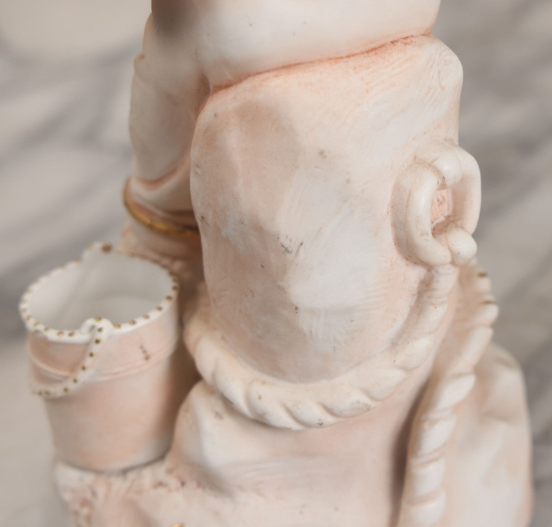 Lot 037 - Vintage Bisque Statue Of Young Blond Child In Large Straw Hat Sitting By Shore With Pail, With Pink Painted Details And Gold Embellishments, Note Chip, Repairs, 12" Height