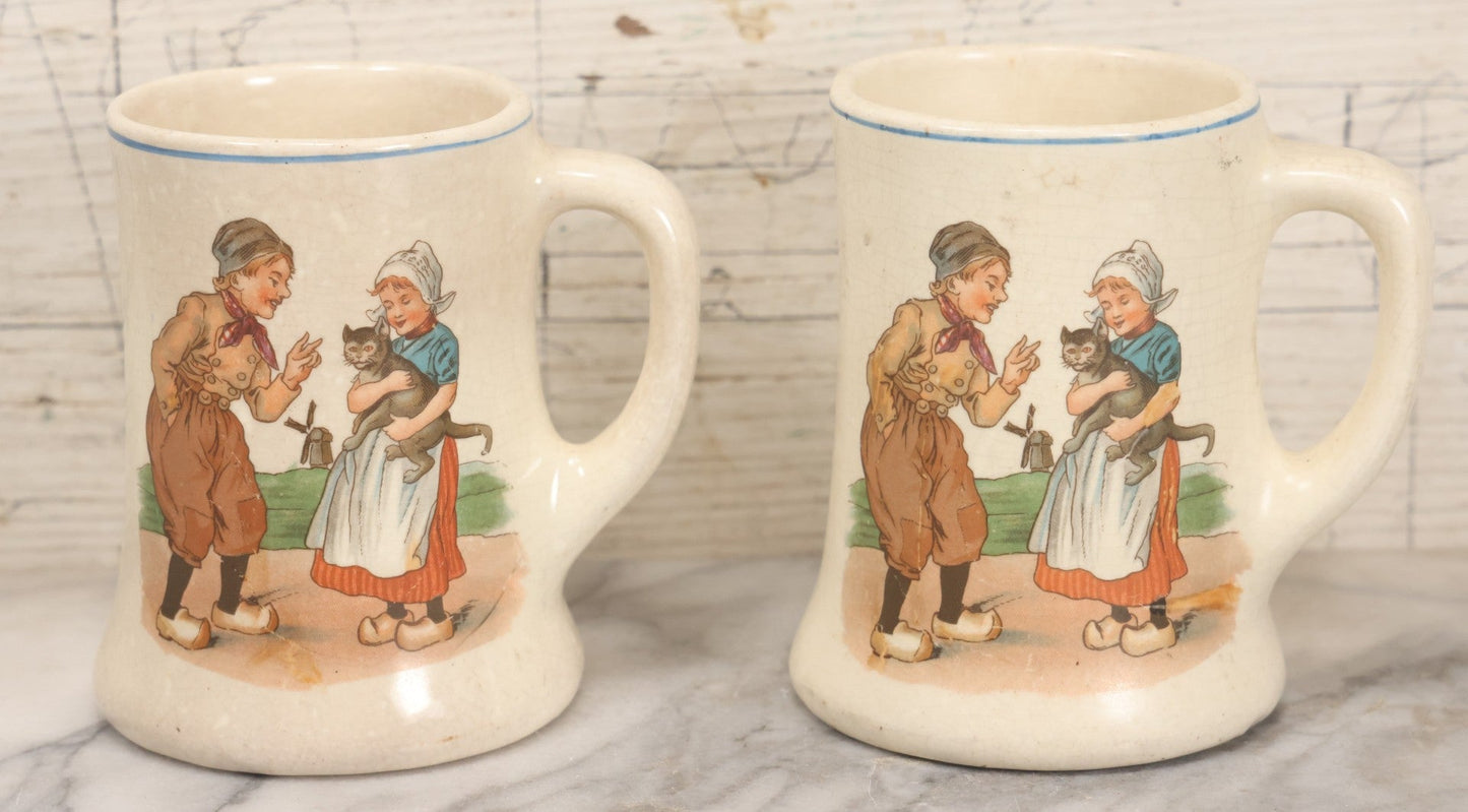 Lot 040 - Pair Of Antique Mugs With Image Of Dutch Children In Clogs Playing With Their Kitten, Windmill In Background