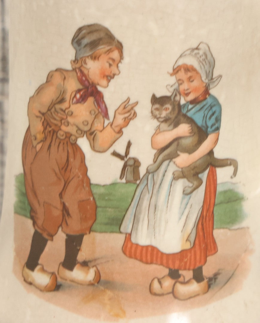 Lot 040 - Pair Of Antique Mugs With Image Of Dutch Children In Clogs Playing With Their Kitten, Windmill In Background
