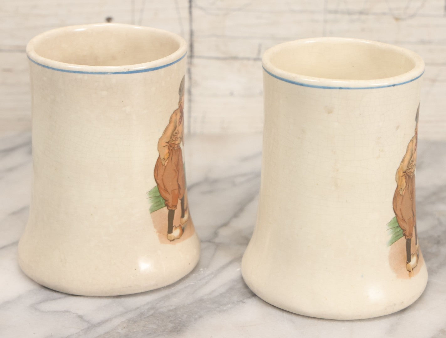 Lot 040 - Pair Of Antique Mugs With Image Of Dutch Children In Clogs Playing With Their Kitten, Windmill In Background