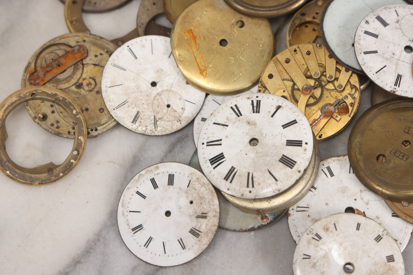 Lot 048 - Mixed Antique Salvage Grouping Of Pocket Watch Parts Including Porcelein Clock Faces, Movements, And Case Parts, 35+ Pieces, Makers Include J.F. Cooper, William Favre, F. Huquenm, M.J. Tobias