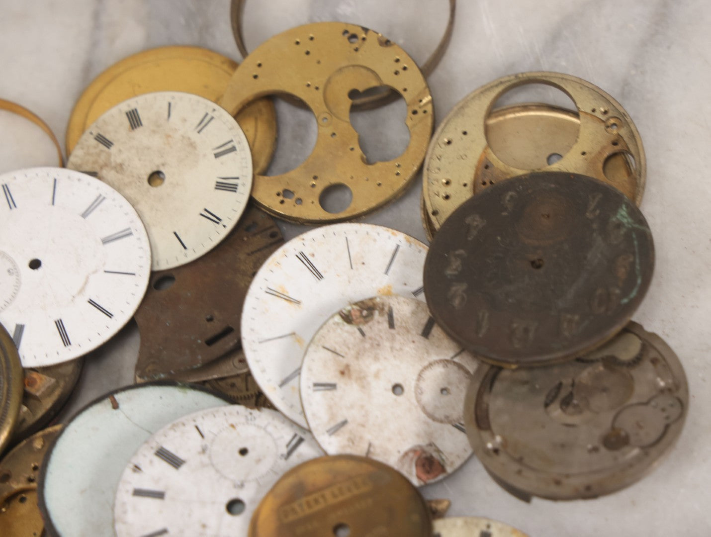 Lot 048 - Mixed Antique Salvage Grouping Of Pocket Watch Parts Including Porcelein Clock Faces, Movements, And Case Parts, 35+ Pieces, Makers Include J.F. Cooper, William Favre, F. Huquenm, M.J. Tobias