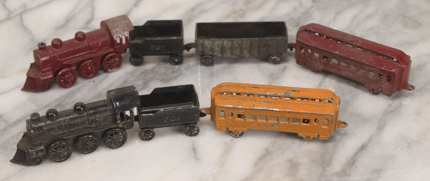 Lot 057 - Grouping Of Seven Vintage Prewar Diecast Train Toys With Original Paint, Including Two Locomotives, Two Tenders, Two Passenger Cars, And One Freight Car