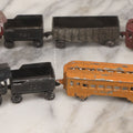 Lot 057 - Grouping Of Seven Vintage Prewar Diecast Train Toys With Original Paint, Including Two Locomotives, Two Tenders, Two Passenger Cars, And One Freight Car
