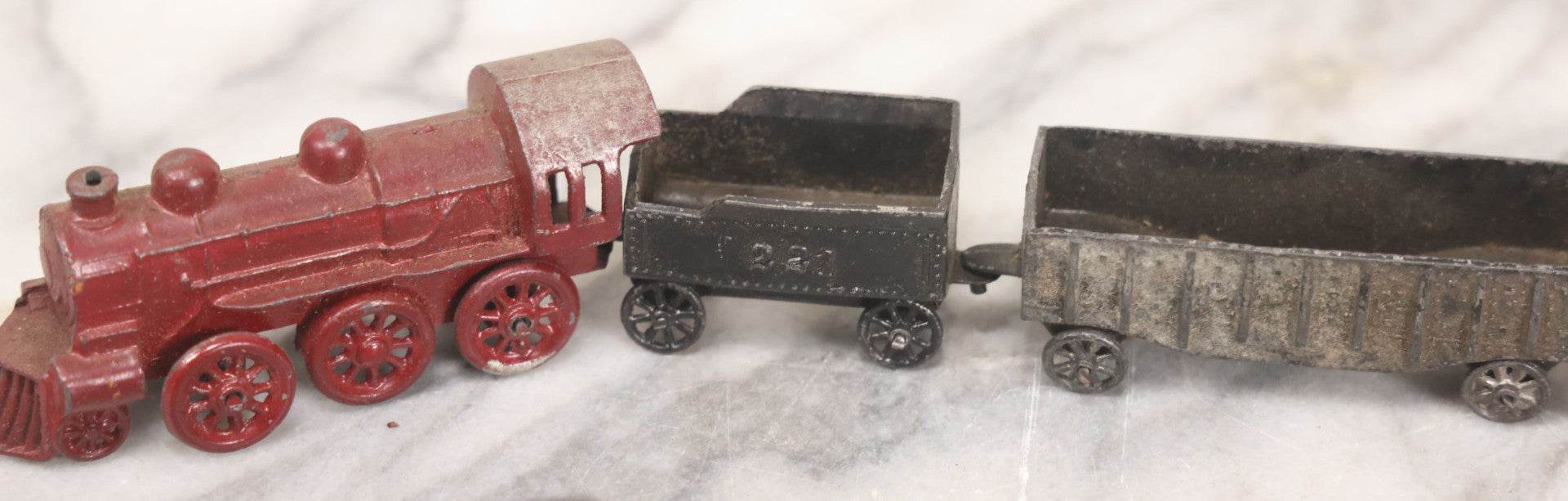 Lot 057 - Grouping Of Seven Vintage Prewar Diecast Train Toys With Original Paint, Including Two Locomotives, Two Tenders, Two Passenger Cars, And One Freight Car