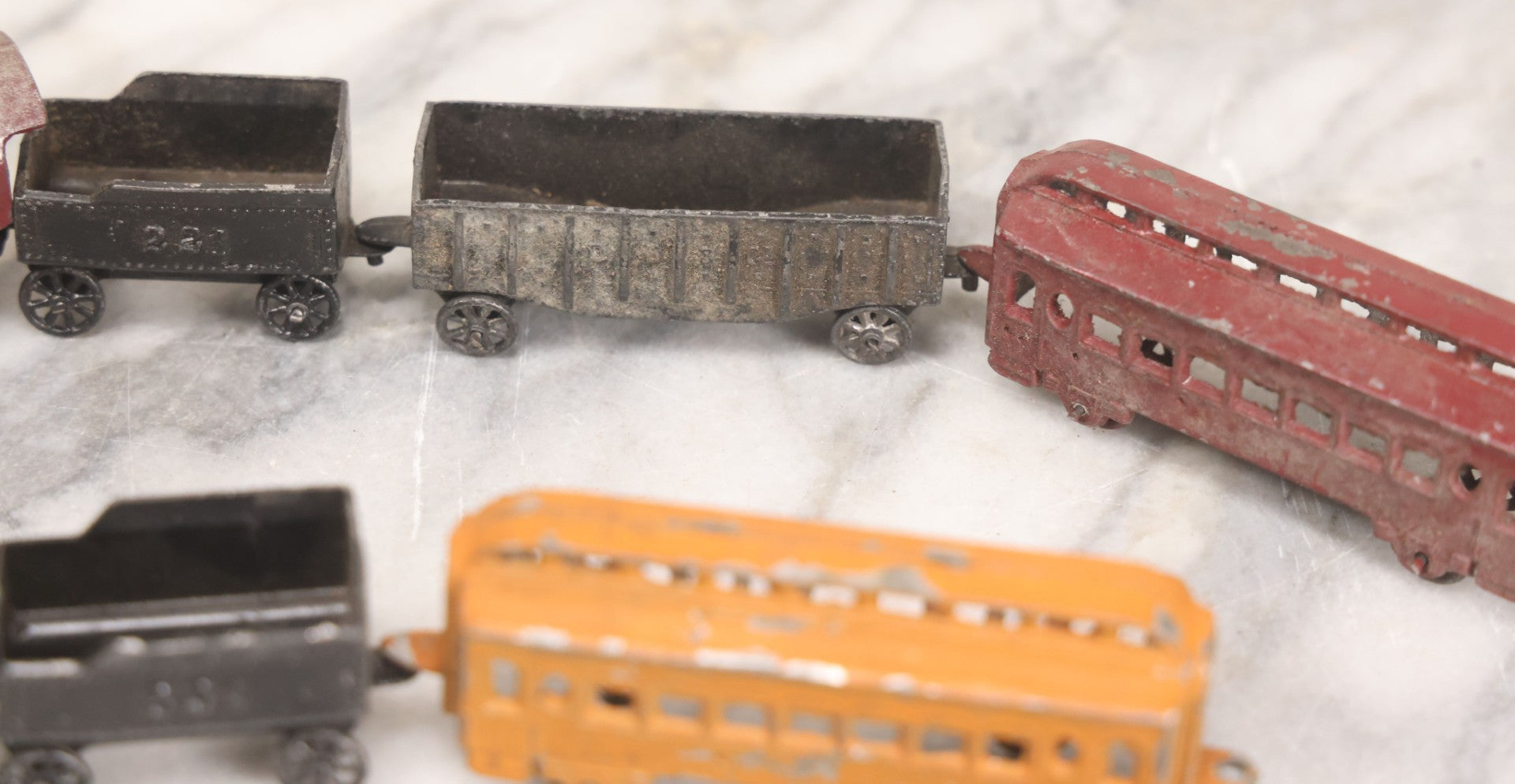 Lot 057 - Grouping Of Seven Vintage Prewar Diecast Train Toys With Original Paint, Including Two Locomotives, Two Tenders, Two Passenger Cars, And One Freight Car