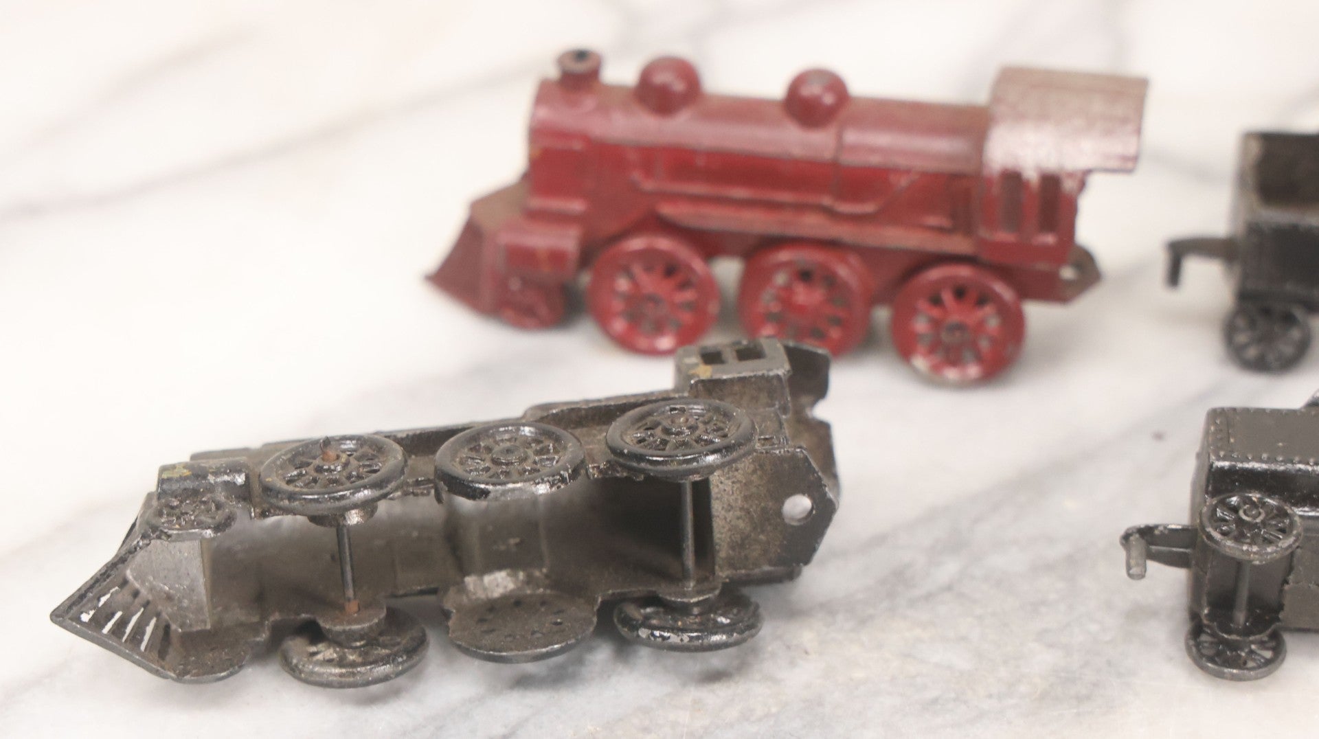 Lot 057 - Grouping Of Seven Vintage Prewar Diecast Train Toys With Original Paint, Including Two Locomotives, Two Tenders, Two Passenger Cars, And One Freight Car