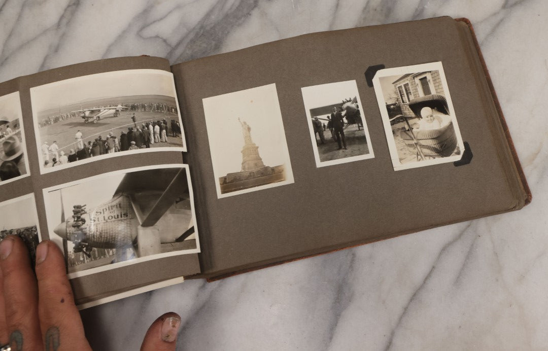 Lot 062 - Vintage Snapshot Photo Album With 125+ Photographs Including Photos Of Spirit Of St. Louis Plane, Redwood Forest, Automobiles, Outings, Comic Wedding Posters, Statue Of Liberty, Beachwear, And More