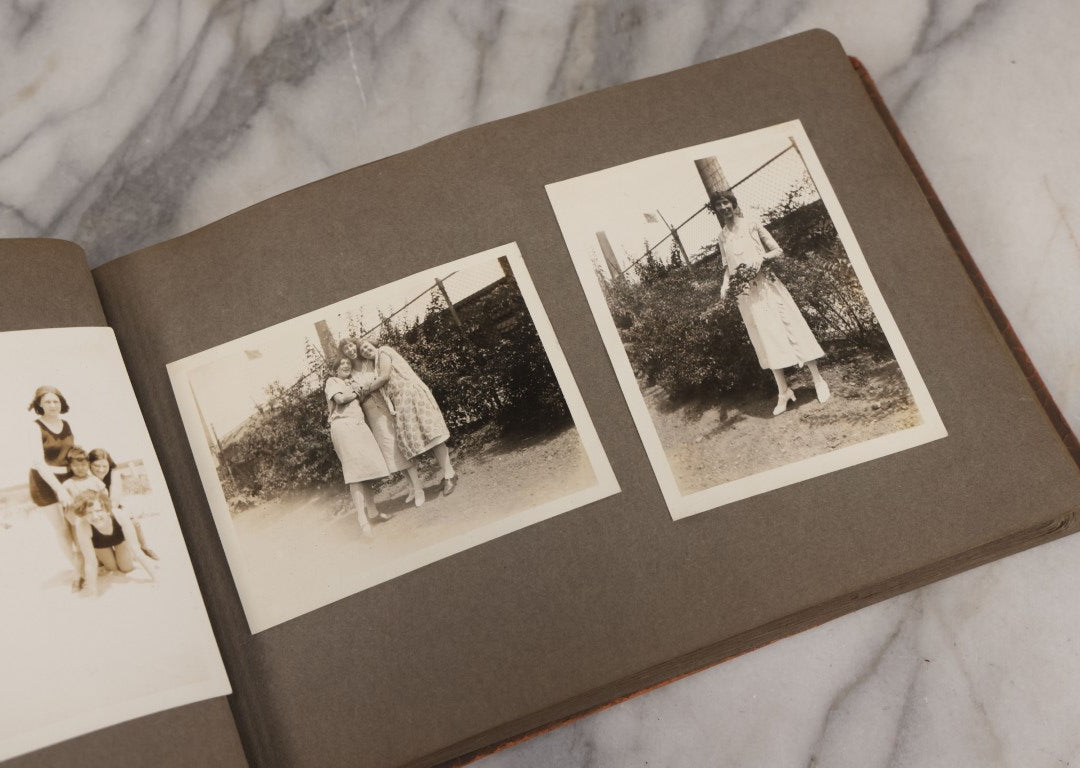 Lot 062 - Vintage Snapshot Photo Album With 125+ Photographs Including Photos Of Spirit Of St. Louis Plane, Redwood Forest, Automobiles, Outings, Comic Wedding Posters, Statue Of Liberty, Beachwear, And More