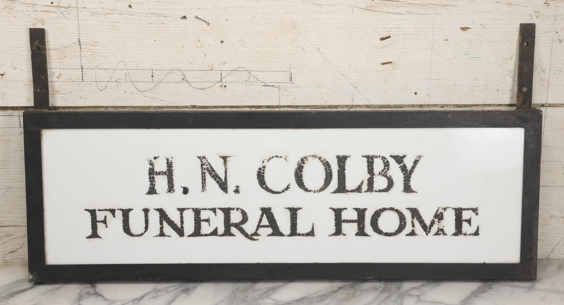 Lot 001 - Vintage Hand Painted Sign For "H.N. Colby Funeral Home" Lawrence, Massachusetts, In Metal Frame With Brackets, Painted On Vitrolite "Better Than Marble Composite Material," Circa 1940s, 25-5/8" L x 8-1/2" H