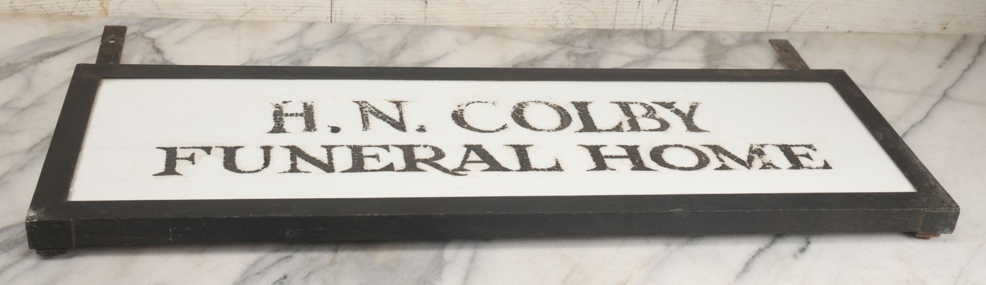 Lot 001 - Vintage Hand Painted Sign For "H.N. Colby Funeral Home" Lawrence, Massachusetts, In Metal Frame With Brackets, Painted On Vitrolite "Better Than Marble Composite Material," Circa 1940s, 25-5/8" L x 8-1/2" H
