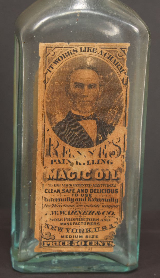 Lot 013 - Antique Bottle With Embossed Text And Original Paper Labels For Renne's Pain Killing Magic Oil Patent Medicine, "It Works Like A Charm; Clean Safe And Delicious" Manufactured By T.W. Warner & Co., New York, 6" Height