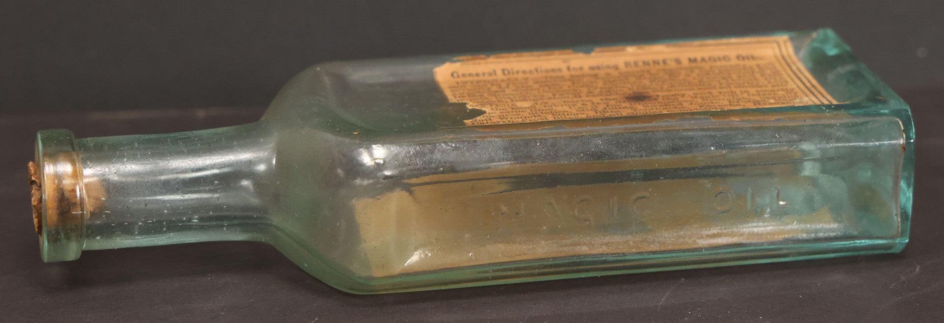 Lot 013 - Antique Bottle With Embossed Text And Original Paper Labels For Renne's Pain Killing Magic Oil Patent Medicine, "It Works Like A Charm; Clean Safe And Delicious" Manufactured By T.W. Warner & Co., New York, 6" Height
