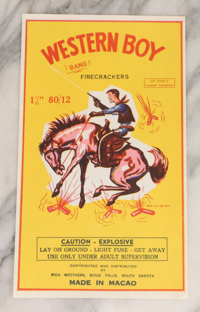 Lot 026 - Vintage Western Boy Firecrackers Lithographed Fireworks Label With Cowboy Graphics, Copyrighted And Distributed By Rich Brothers, Sioux Falls, South Dakota, Made In Macao